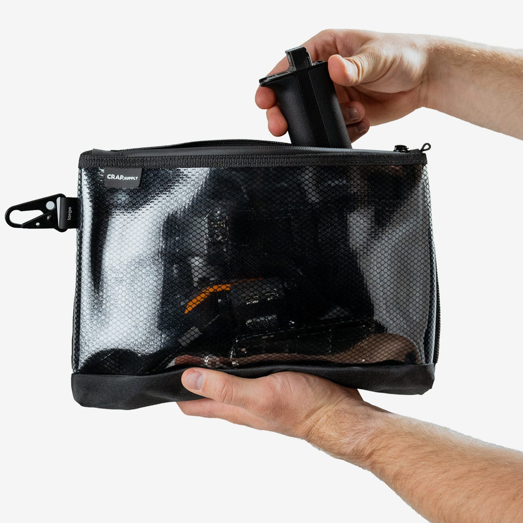 A compact filmmaker kit laid out on a table before packing into a single backpack