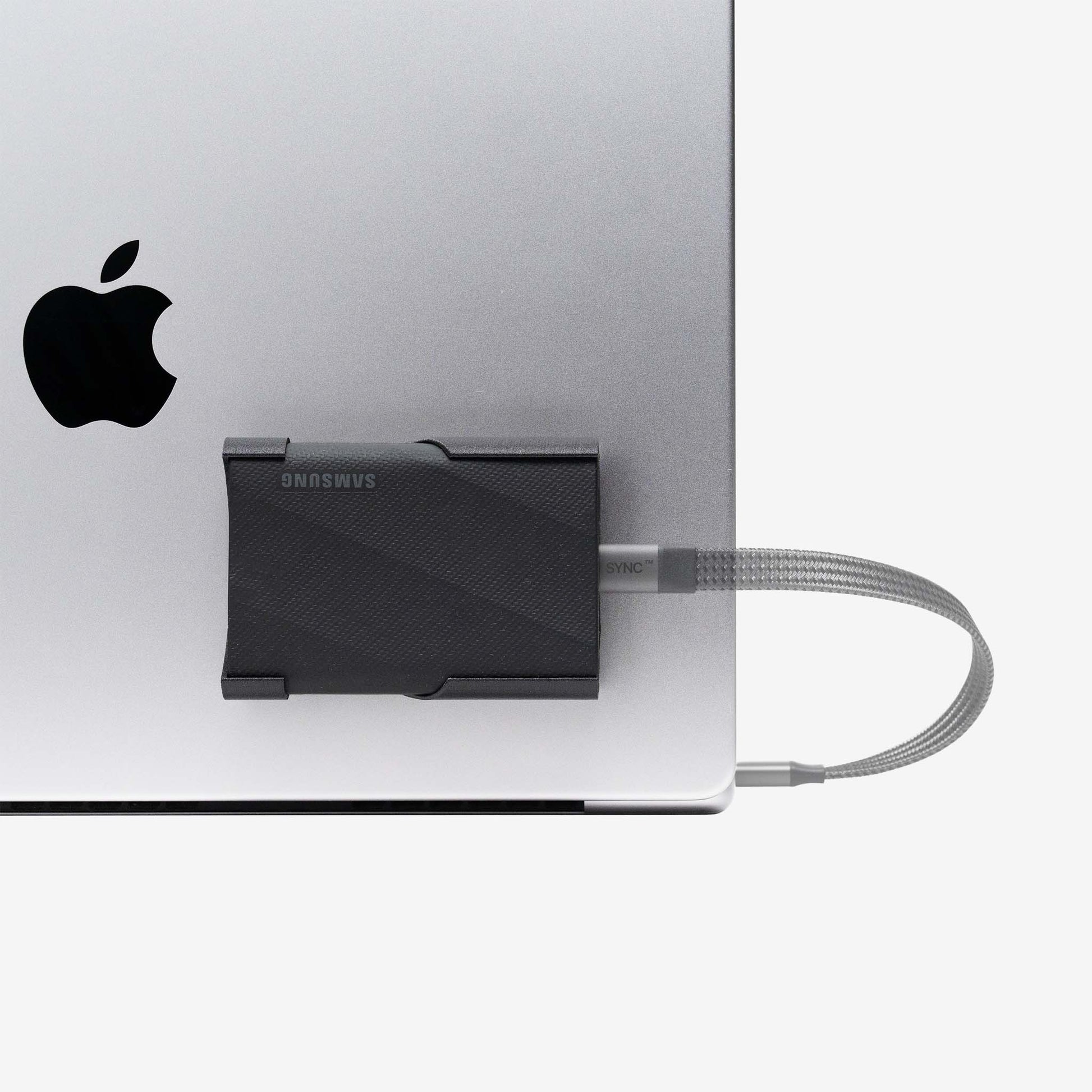 Black SCREENMOUNT precision-fit attached to a laptop holding a Samsung T-series drive securely in place