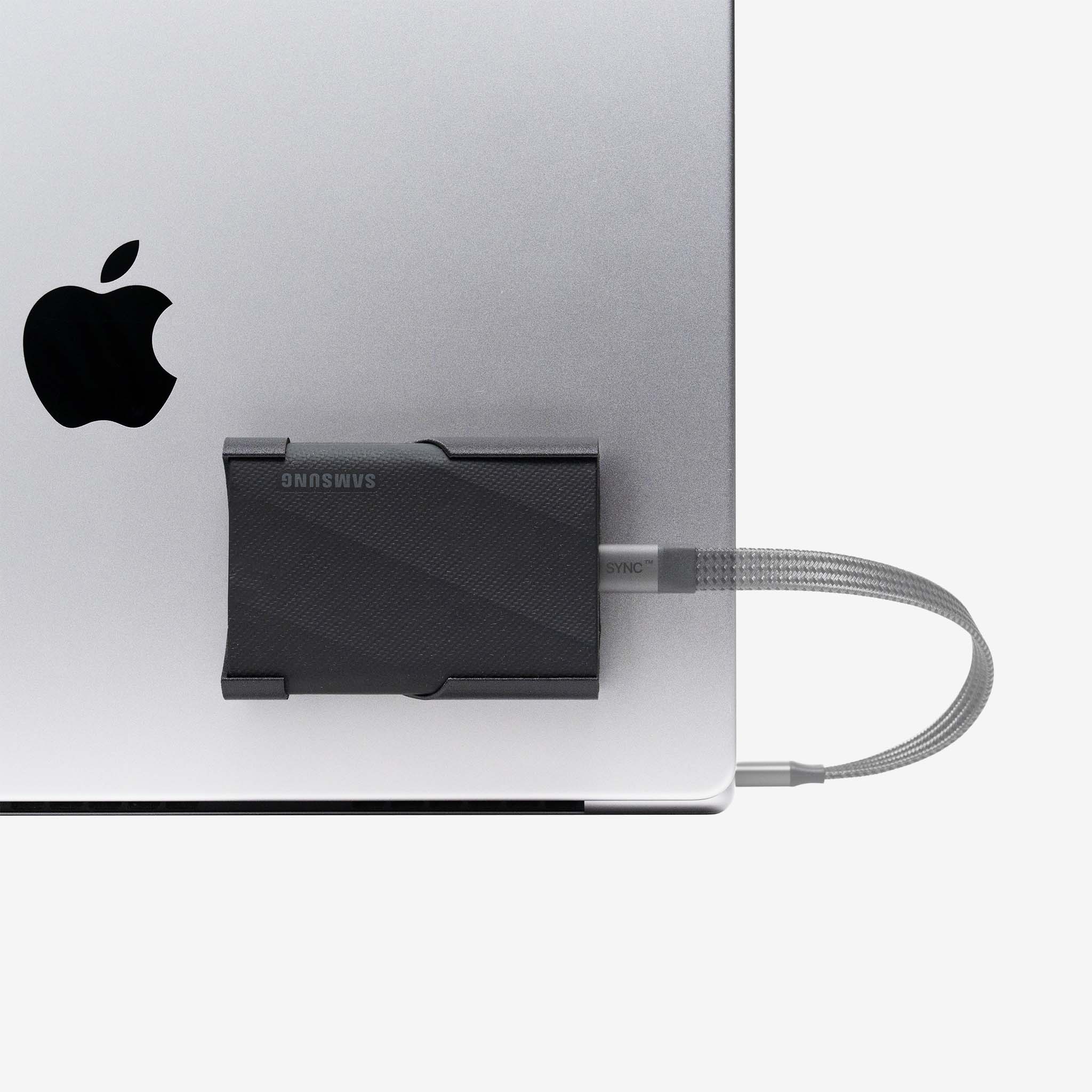 Black SCREENMOUNT precision-fit attached to a laptop holding a Samsung T-series drive securely in place