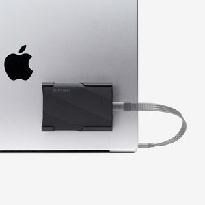 Black SCREENMOUNT precision-fit attached to a laptop holding a Samsung T-series drive securely in place