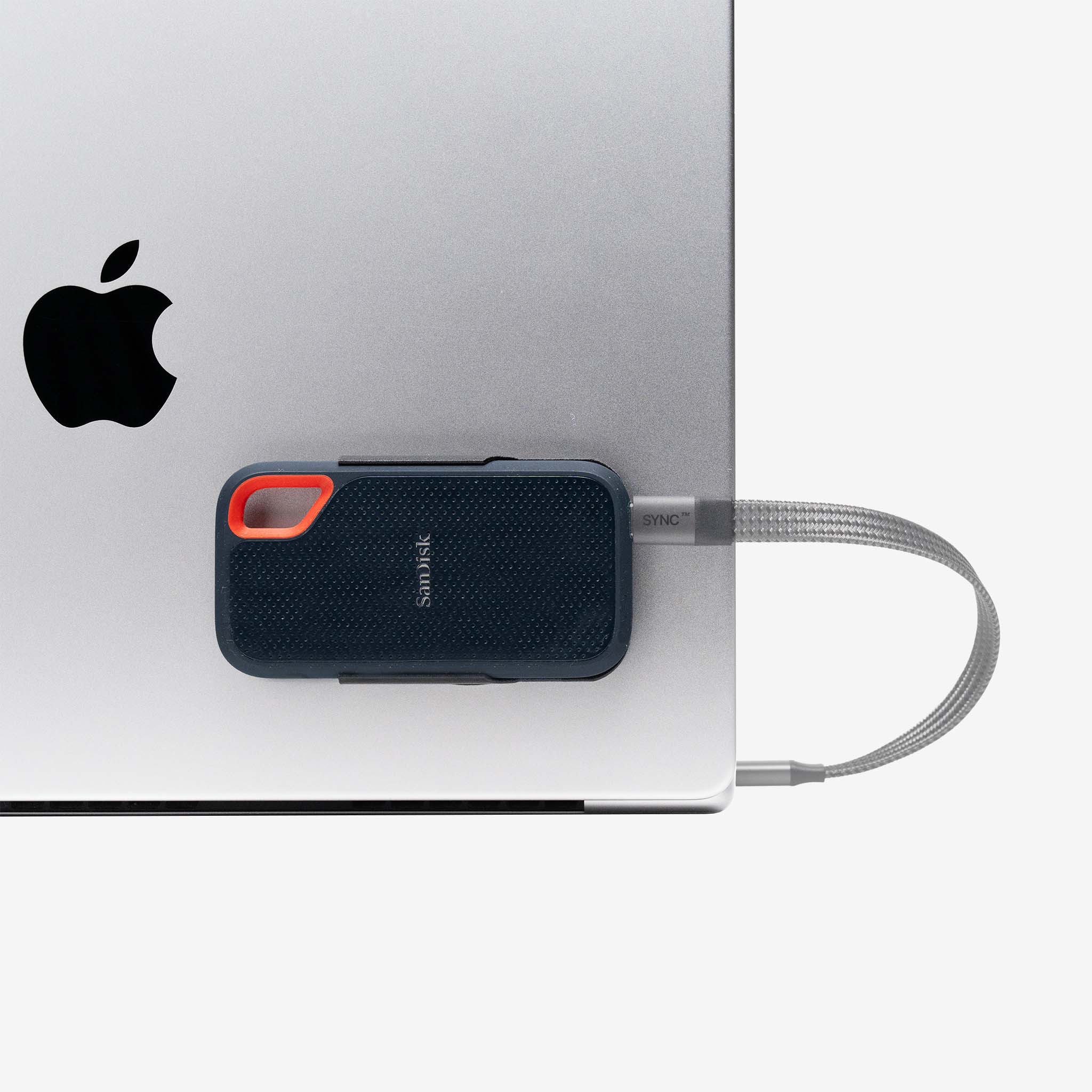 SanDisk Extreme external SSD mounted securely on a laptop using the SCREENMOUNT accessory to prevent dangling drives
