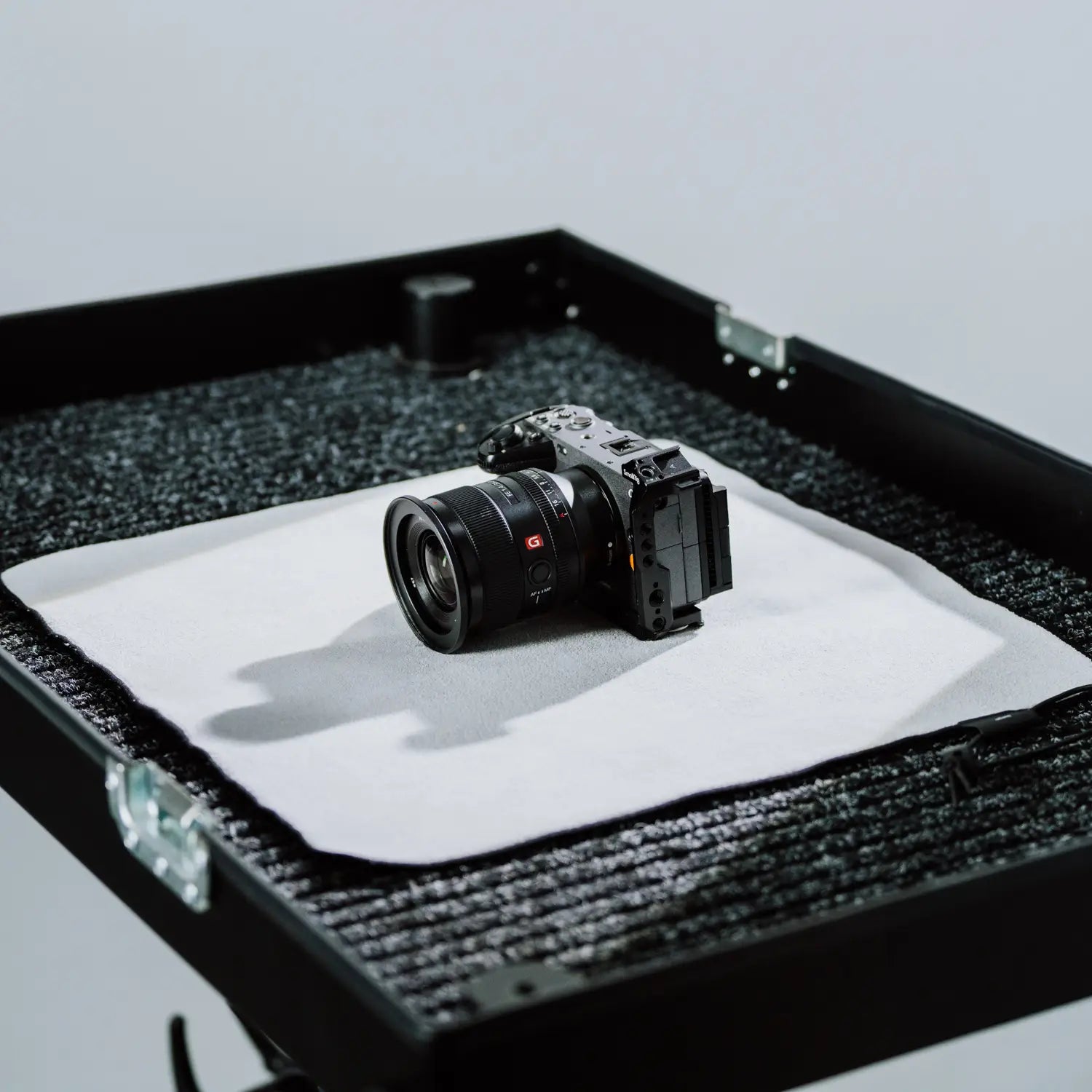 Large waterproof wrap cloth protecting a camera inside a textured black case against spills and drops.